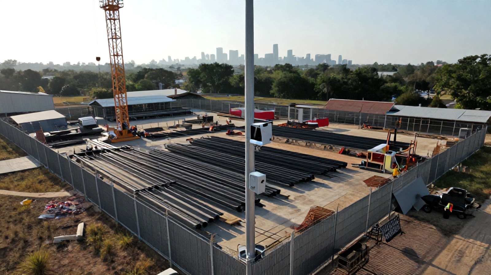 Aerial close-up comparing a fixed time-lapse camera mount to drone perspective on a Texas construction site