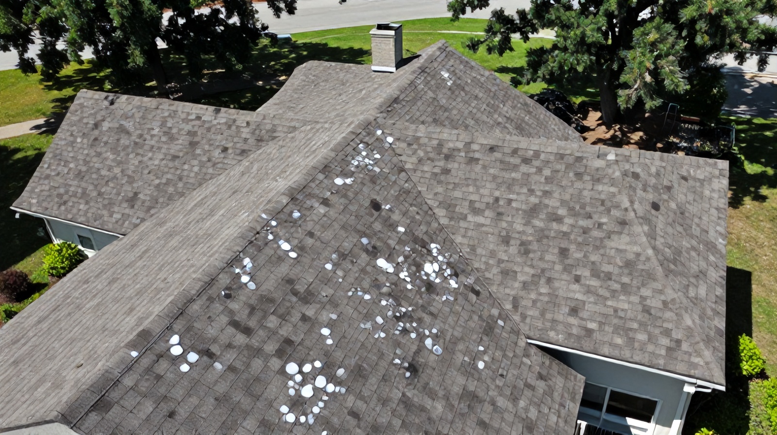 Top-down aerial view of a hail-damaged asphalt shingle roof in Central Texas