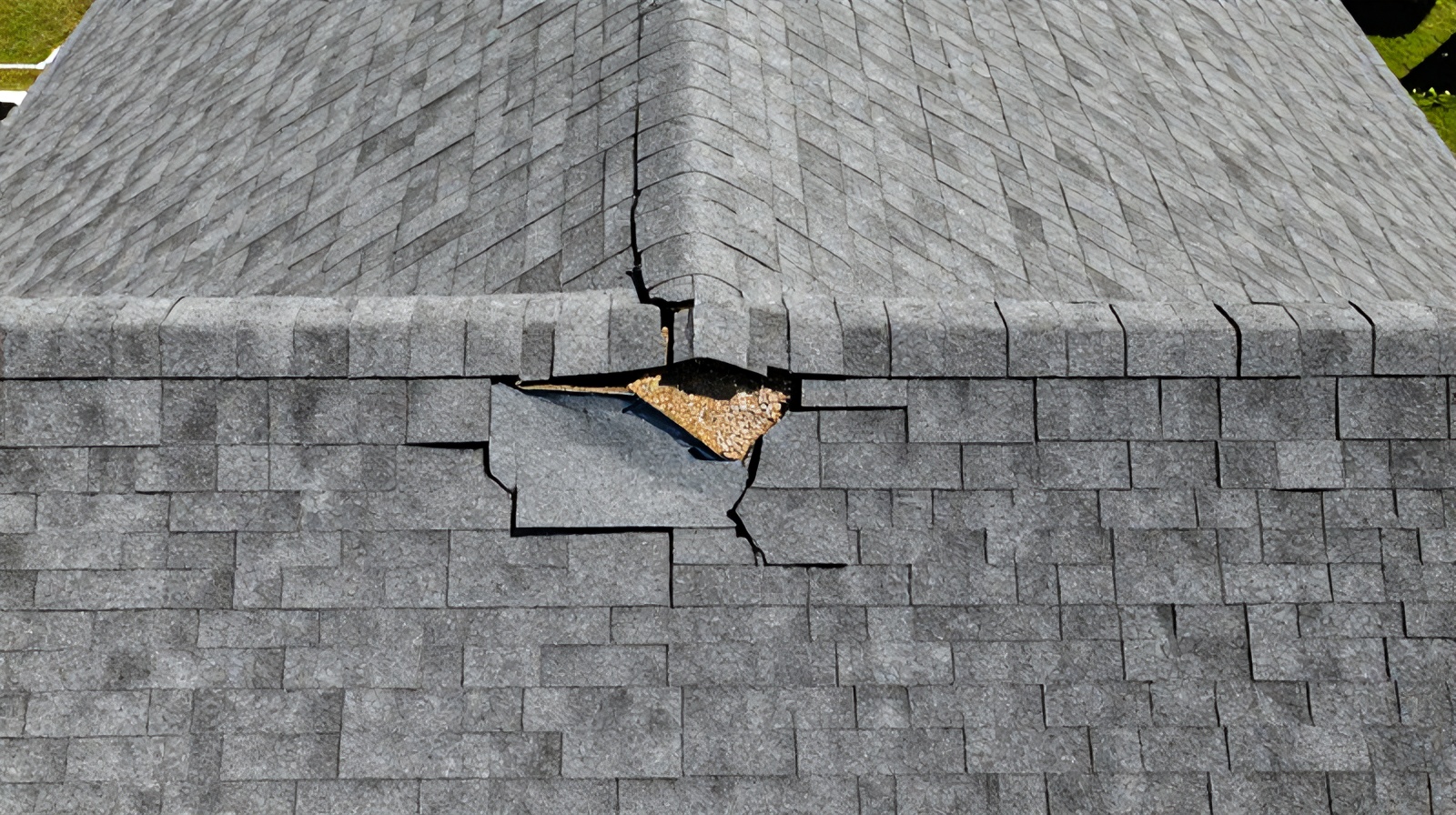 Close aerial view highlighting cracked shingles and flashing damage on a Texas home's roof