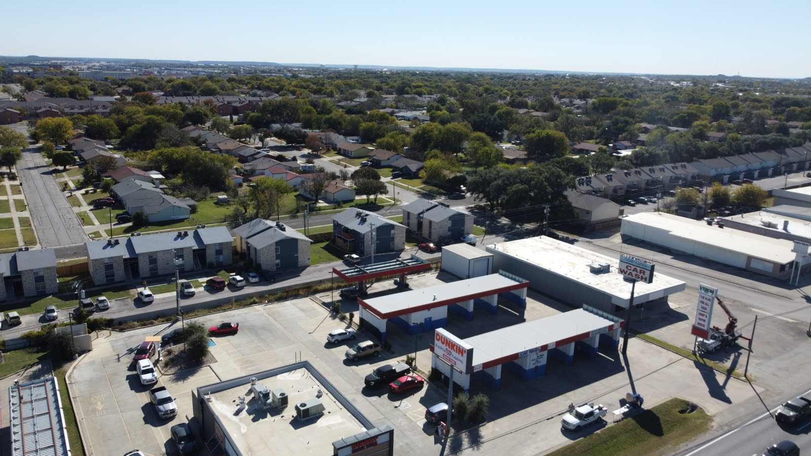 Aerial drone view of an Austin apartment community with pool deck and courtyard at golden hour
