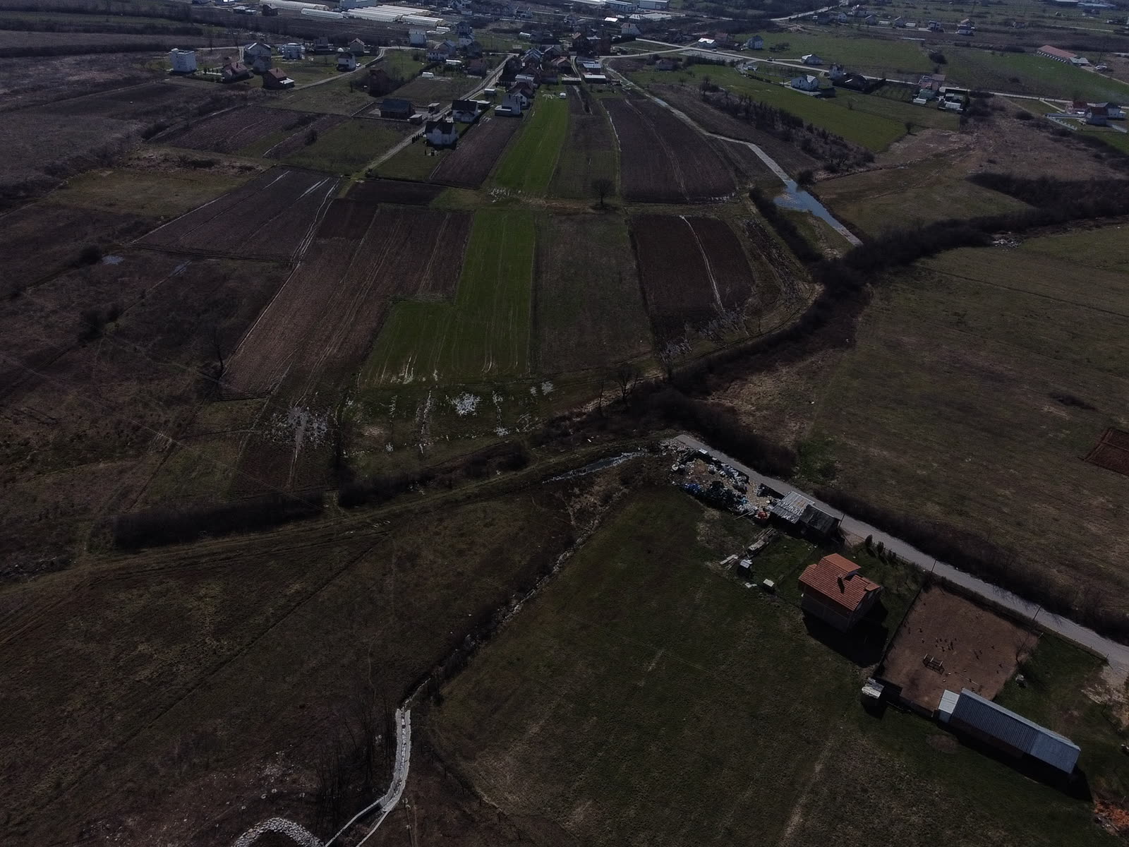 Drone capturing survey imagery over an open site with a ground control target