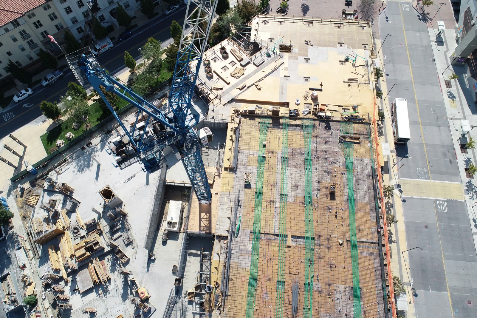 Aerial view of an active commercial construction site with tower crane