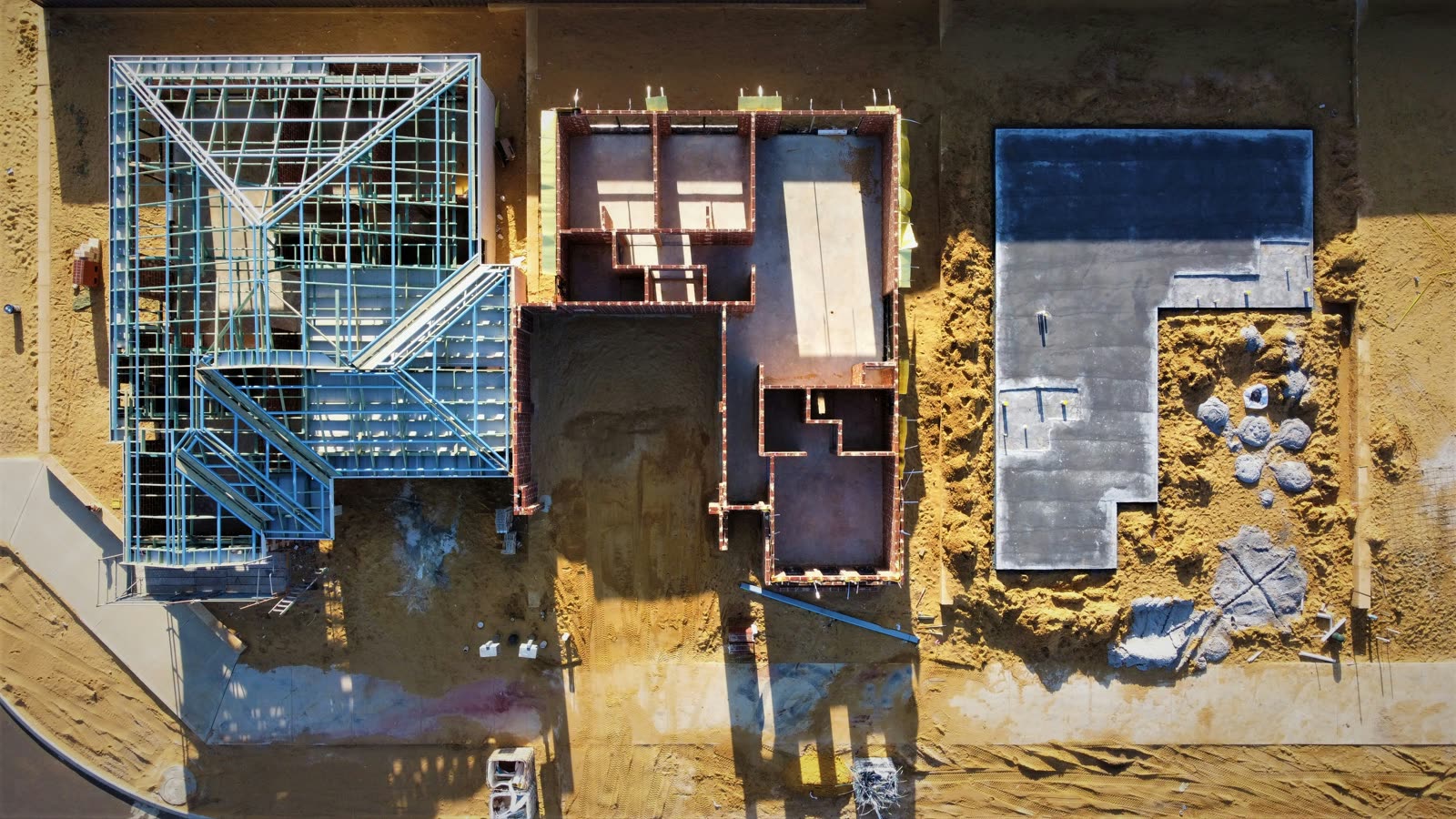 Top-down aerial view of residential framing and foundation stages